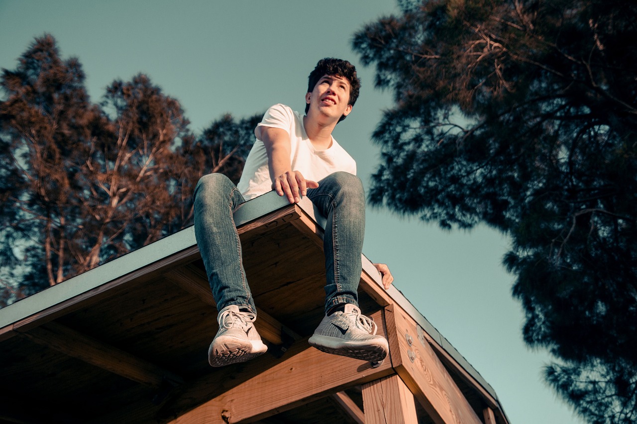 A guy sitting on a roof thinking about preparing your roof for winter