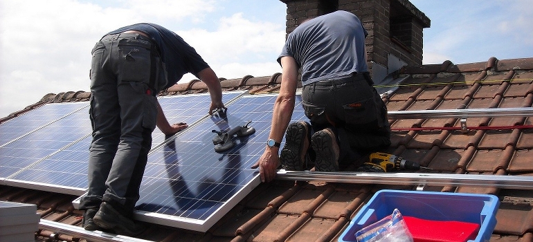 Technicians installing rooftop solar panels