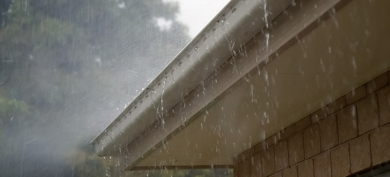 A roof and gutters under heavy rain